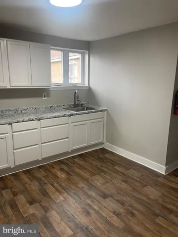 a view of a kitchen with granite countertop cabinets a sink and dishwasher