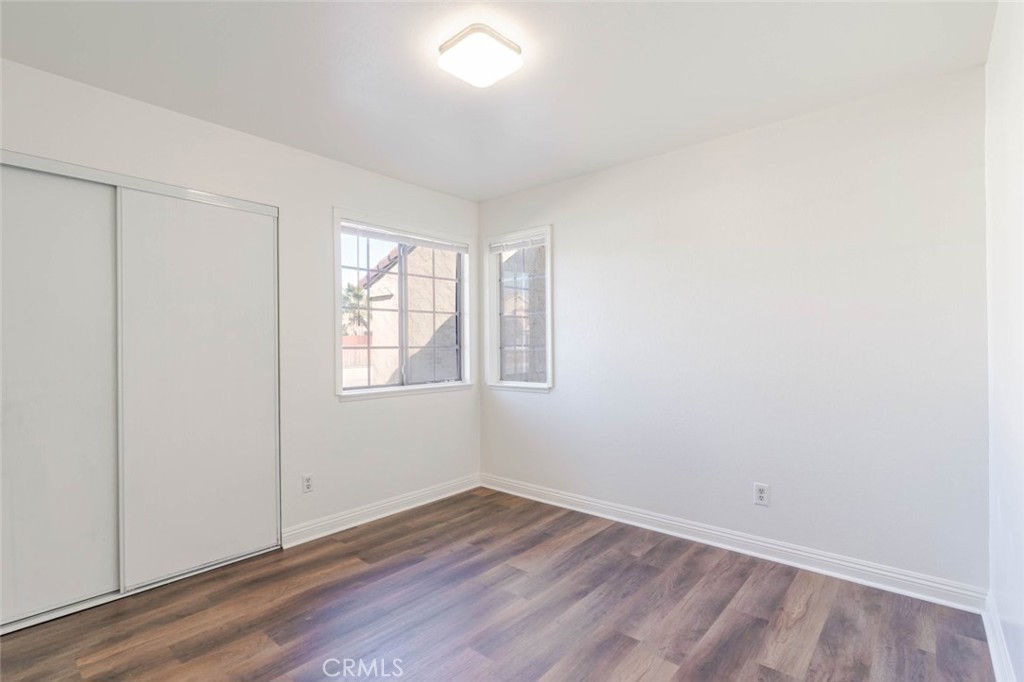 4906 Pacifica Avenue Palmdale, CA 93552 - Photo 13 of 36 an empty room with wooden floor and windows