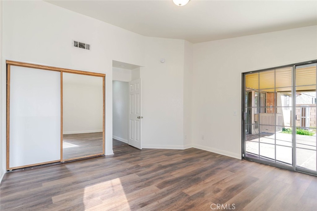 4906 Pacifica Avenue Palmdale, CA 93552 - Photo 22 of 36 a view of an empty room with wooden floor and a window