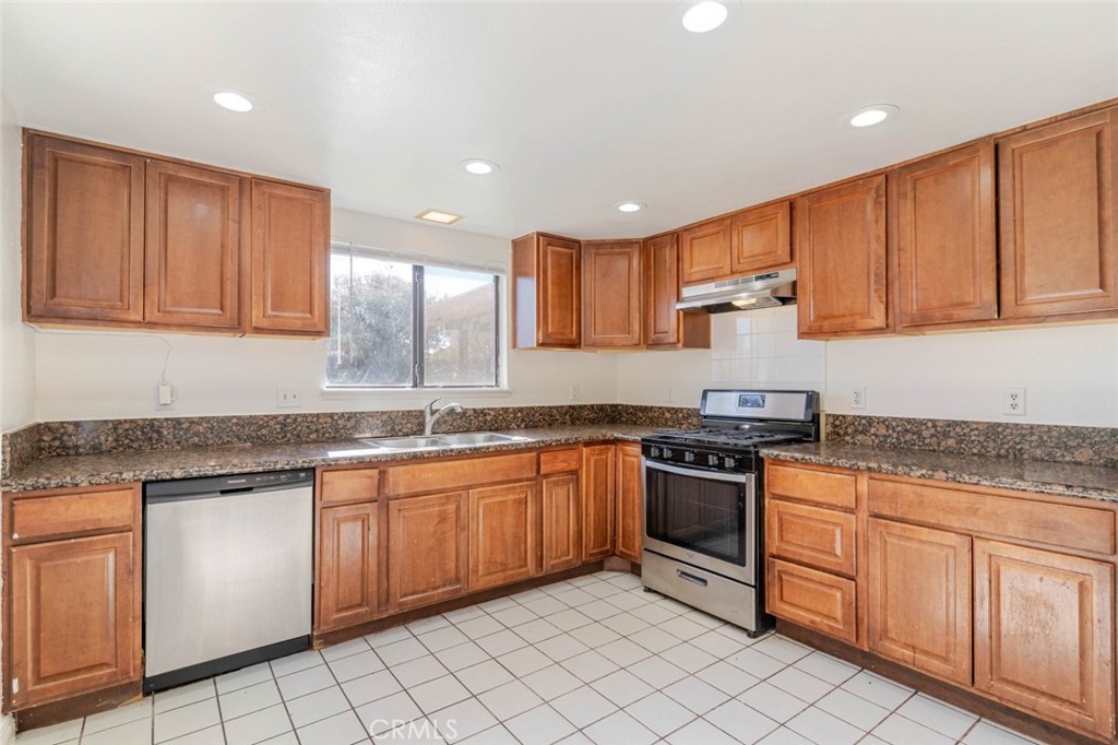 4906 Pacifica Avenue Palmdale, CA 93552 - Photo 5 of 36 a kitchen with stainless steel appliances granite countertop a stove sink and cabinets