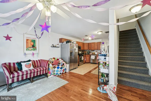 a kitchen view with stainless steel appliances wooden floor and chandelier