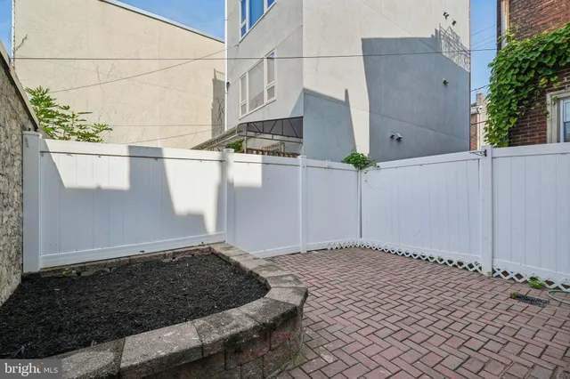 a view of a house with backyard and wooden fence