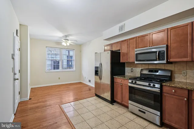 a kitchen with stainless steel appliances granite countertop a refrigerator and a stove