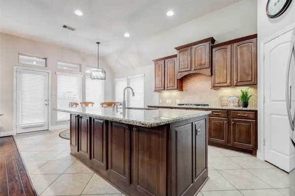 a kitchen with granite countertop a sink a stove and cabinets