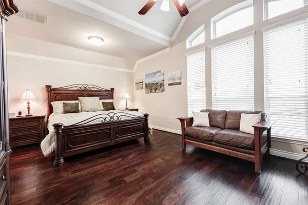 a bedroom with a bed wooden floor and window