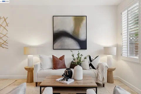 a living room with furniture a flat screen tv and a window