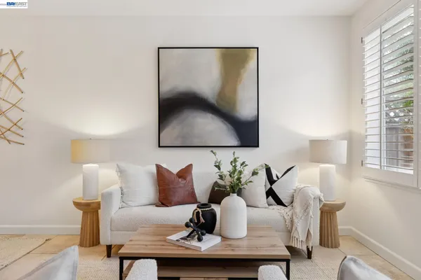 a living room with furniture a flat screen tv and a window