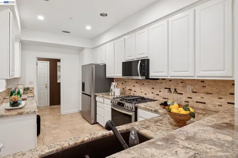 a kitchen with stainless steel appliances granite countertop a sink stove and refrigerator