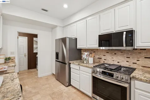 a kitchen with a sink and living room view