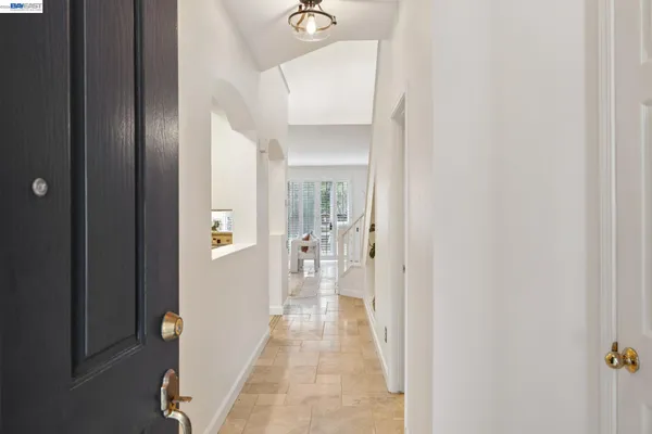 a view of a hallway with wooden floor and a living room