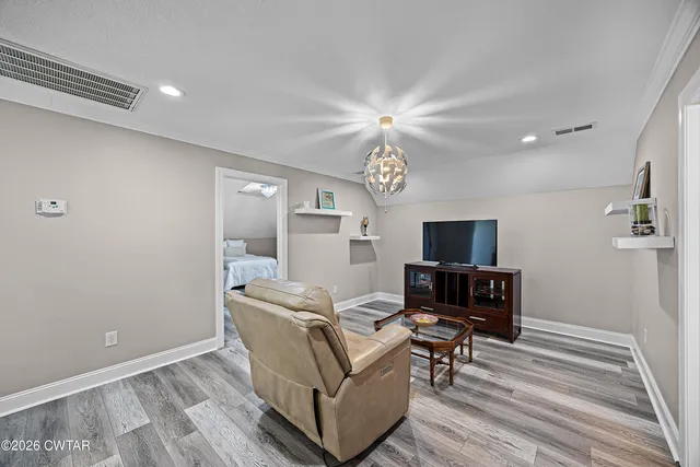 a living room with furniture wooden floor and a flat screen tv