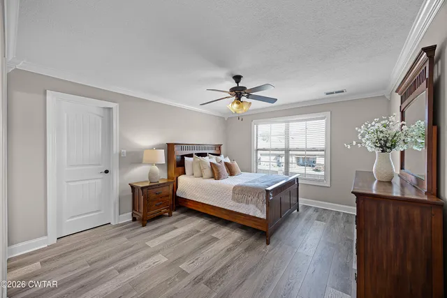 a spacious bedroom with a bed and a potted plant