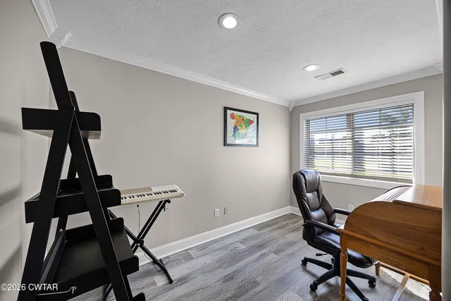 a view of a workspace with furniture and a window