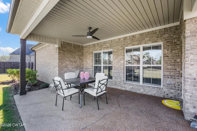 a backyard of a house with dining table and chairs