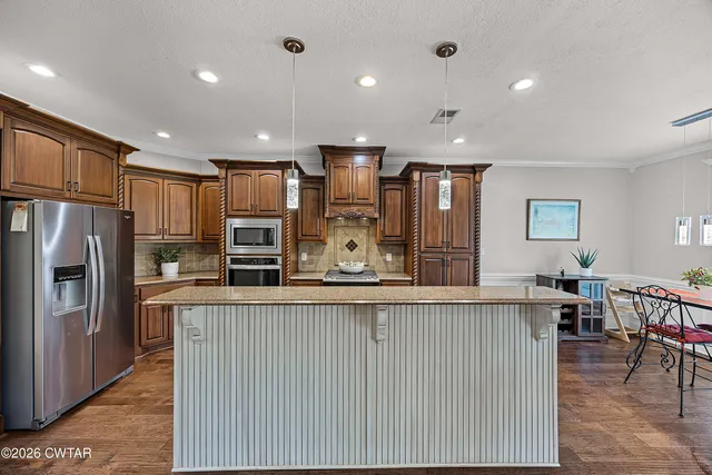 a large kitchen with stainless steel appliances lots of counter space and windows