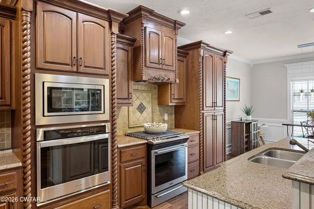 a kitchen with stainless steel appliances granite countertop a stove microwave and refrigerator