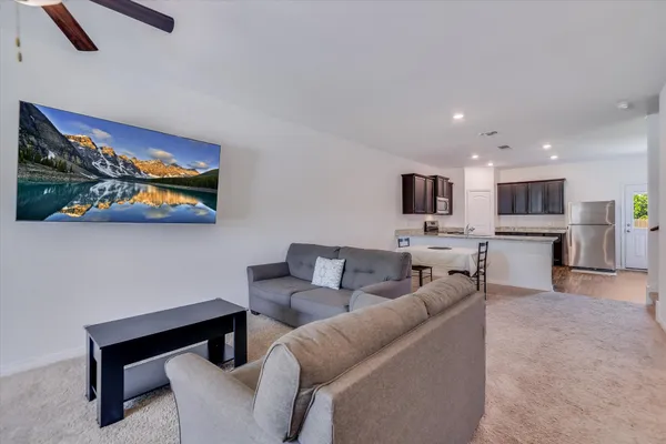 a living room with furniture kitchen view and a fireplace