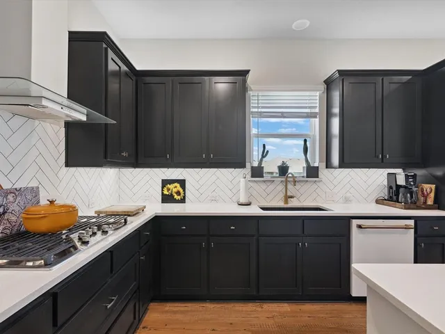 a kitchen with stainless steel appliances kitchen island granite countertop a sink and a stove