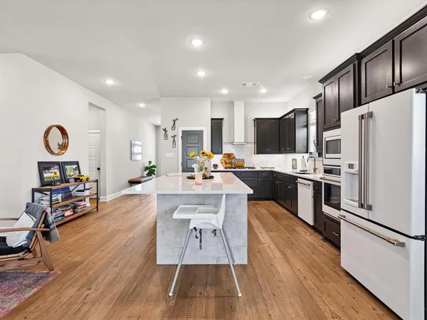 a kitchen with stainless steel appliances kitchen island granite countertop a sink and a stove