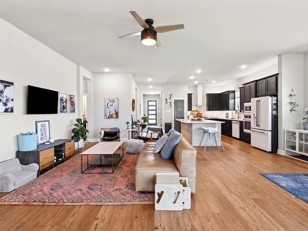 a living room with furniture kitchen view and a flat screen tv