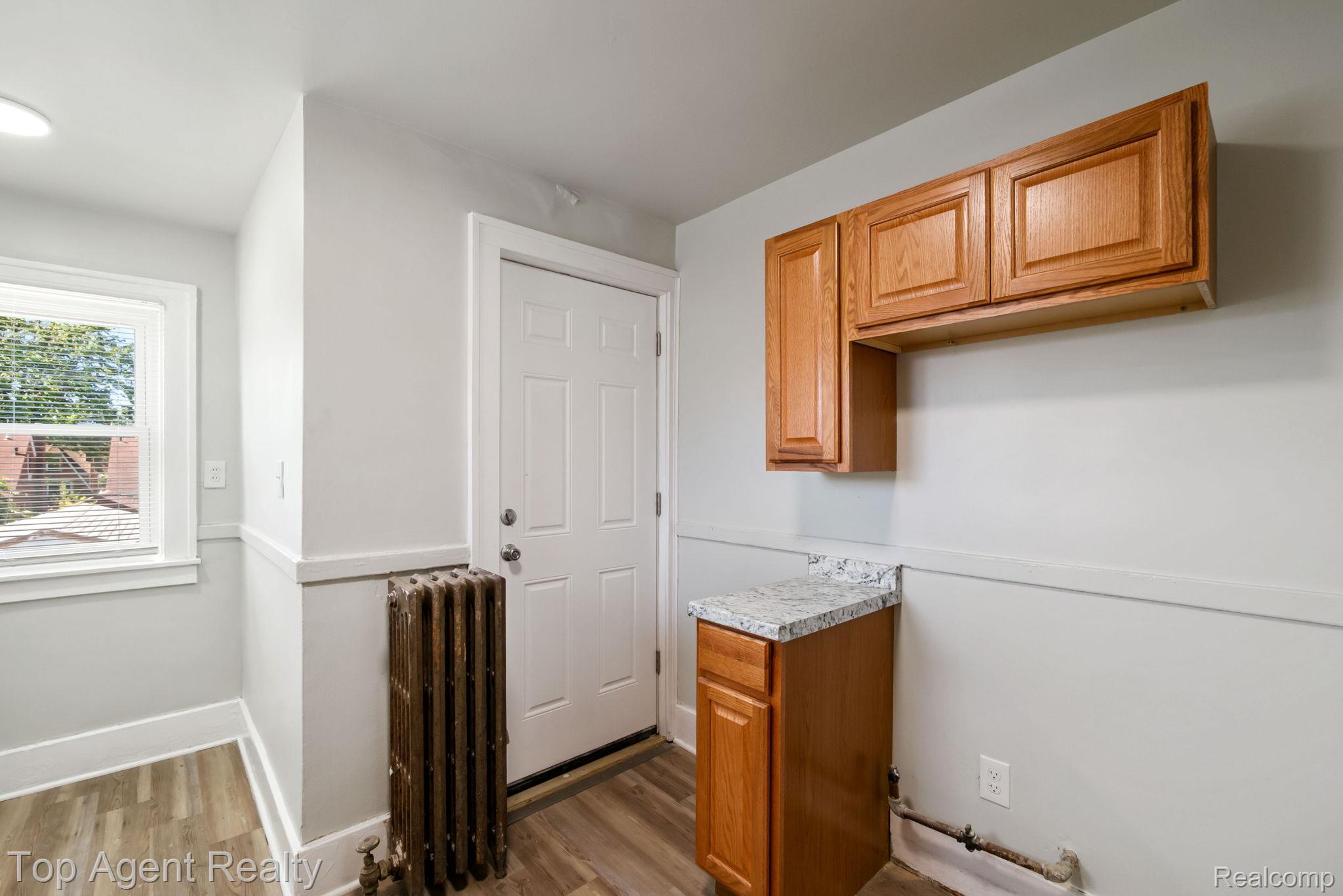 19217 Reno Street Detroit, MI 48205 - Photo 27 of 45 Wood-finish flooring, white paneled door, wood cabinetry with a speckled countertop, and recessed lighting