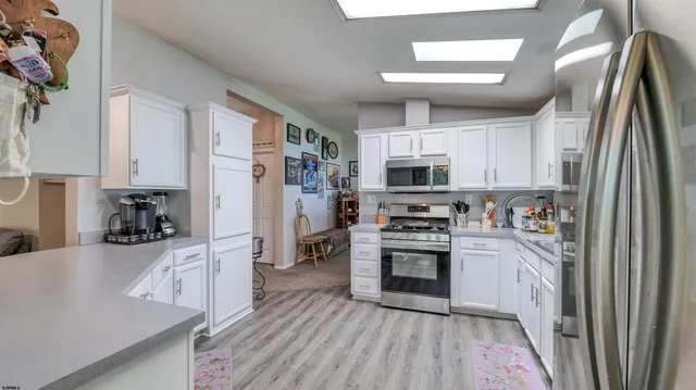 a kitchen with stainless steel appliances granite countertop a refrigerator a stove top oven a sink and dishwasher