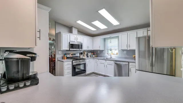 a kitchen with granite countertop stainless steel appliances and refrigerator