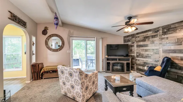 a living room with furniture a flat screen tv and a large window