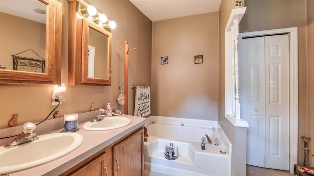 a bathroom with a tub sink and mirror