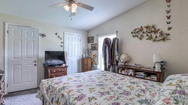 a bedroom with a bed dresser and a flat tv screen