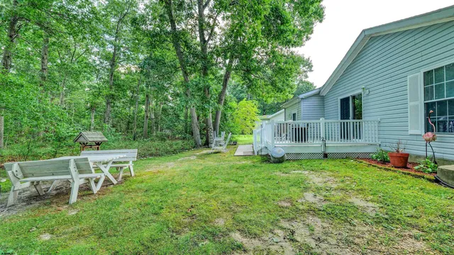 a backyard of a house with table and chairs