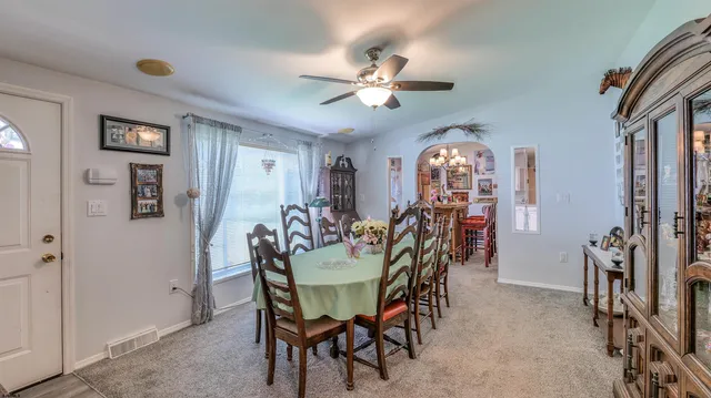 a view of a dining room with furniture and a chandelier