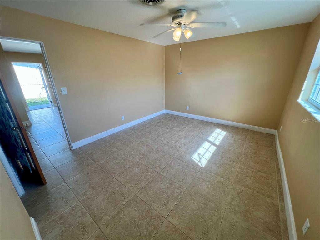11315 3rd Street East Treasure Island, FL 33706 - Photo 21 of 46 en empty room with windows and chandelier fan