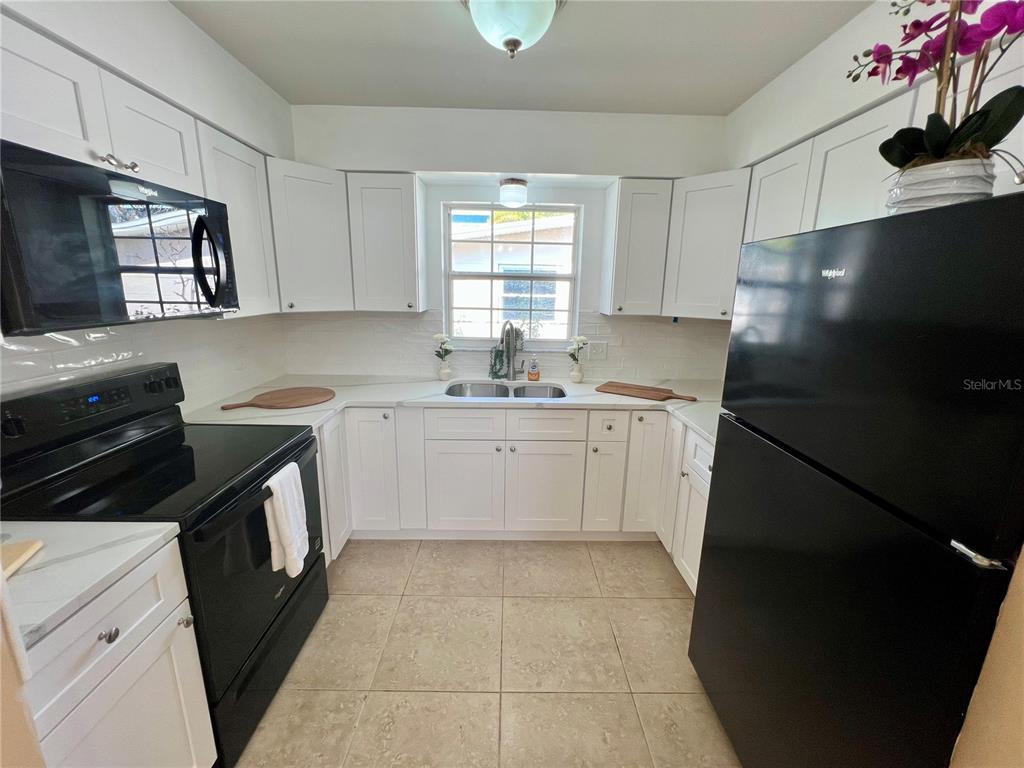 11315 3rd Street East Treasure Island, FL 33706 - Photo 4 of 46 a kitchen with a sink stove and refrigerator
