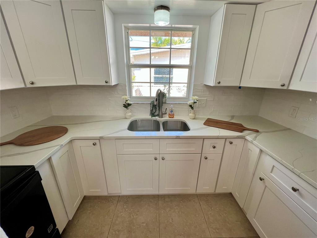 11315 3rd Street East Treasure Island, FL 33706 - Photo 5 of 46 a kitchen with white cabinets and sink