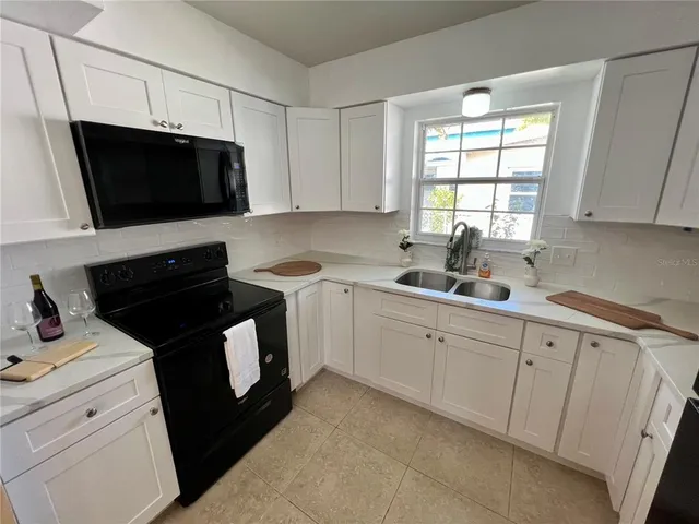 a kitchen with a sink stove and microwave