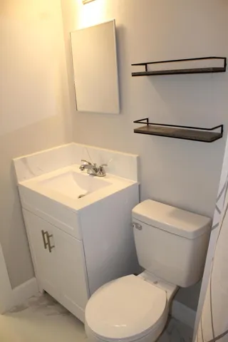 a white toilet sitting next to a bathroom sink