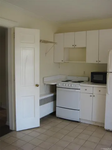 a kitchen with white cabinets and white appliances