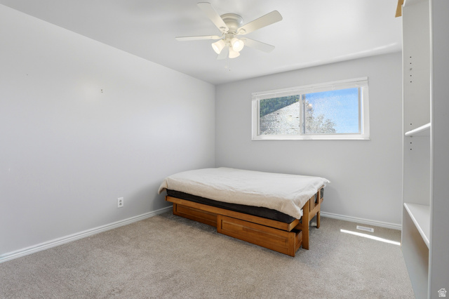 4245 3320 East Holladay, UT 84124 - Photo 25 of 51 Bedroom featuring light gray wall tones, neutral carpeting, a white ceiling fan, and a built-in shelving unit