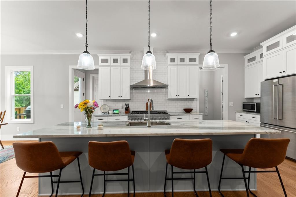 4847 Destitute Way Gainesville, GA 30506 - Photo 12 of 67 a kitchen with stainless steel appliances granite countertop a sink a stove a refrigerator and white cabinets with wooden floor
