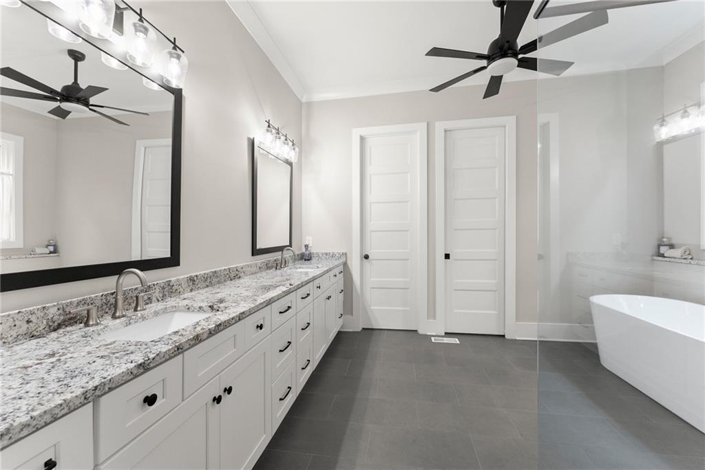 4847 Destitute Way Gainesville, GA 30506 - Photo 28 of 67 a bathroom with a double vanity sink and mirror with bathtub