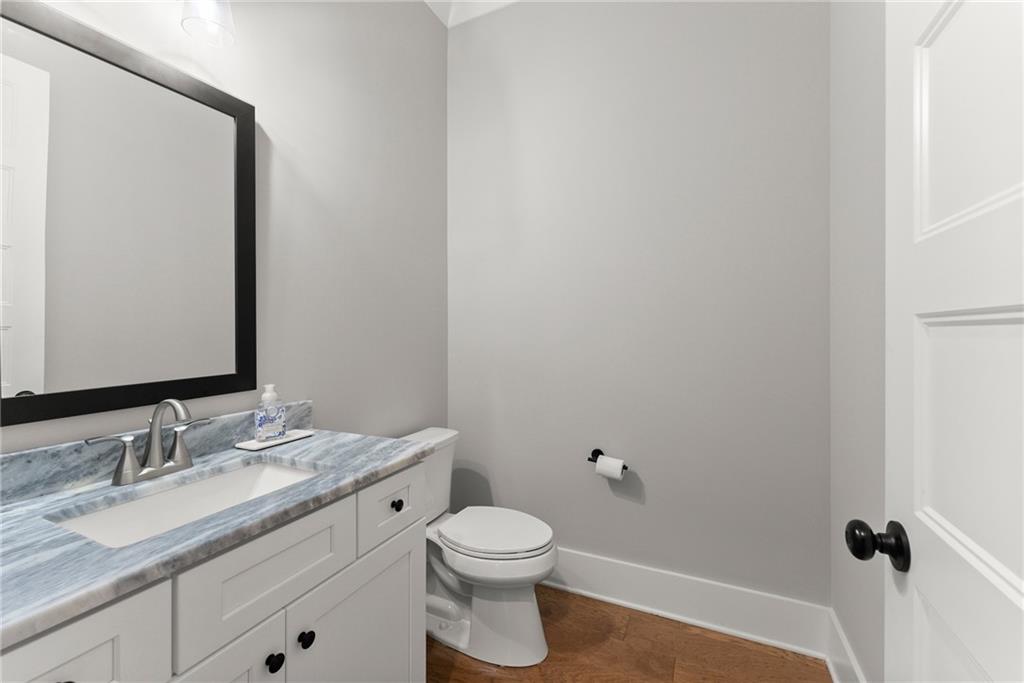 4847 Destitute Way Gainesville, GA 30506 - Photo 33 of 67 a bathroom with a granite countertop sink a toilet and a mirror