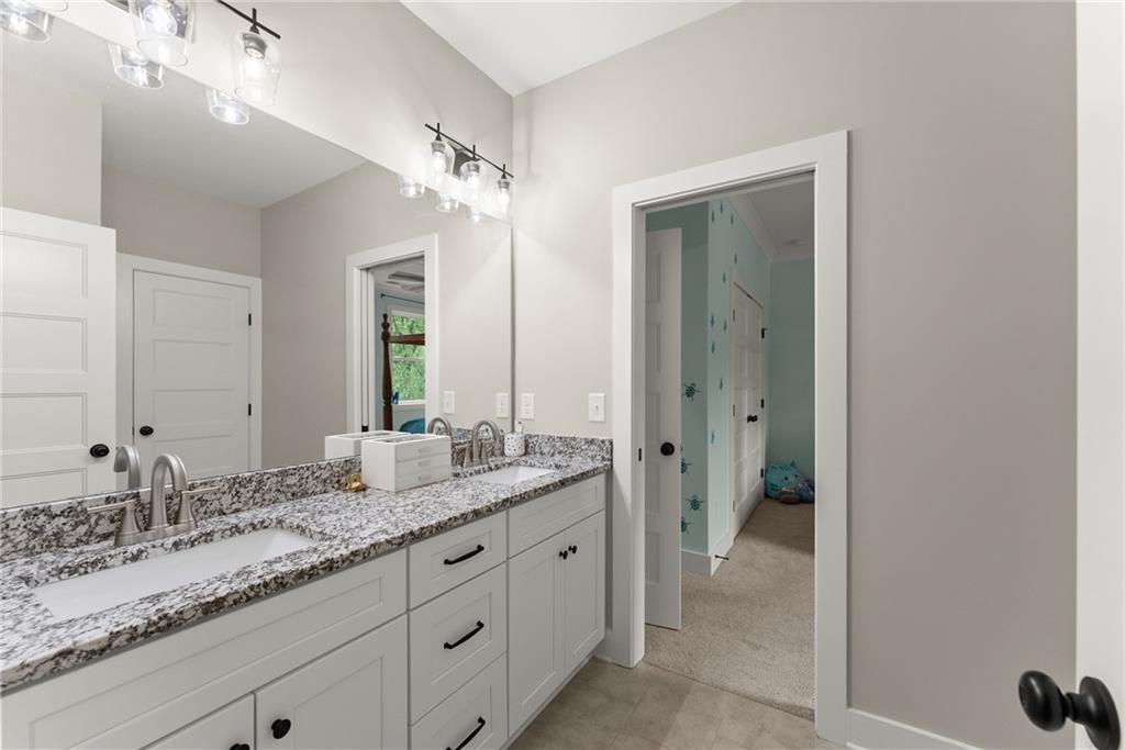 4847 Destitute Way Gainesville, GA 30506 - Photo 42 of 67 a bathroom with a granite countertop double vanity sink a mirror and a
