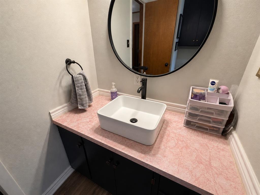 1706 North Ave H Haskell, TX 79521 - Photo 16 of 25 a bathroom with a sink vanity and a mirror