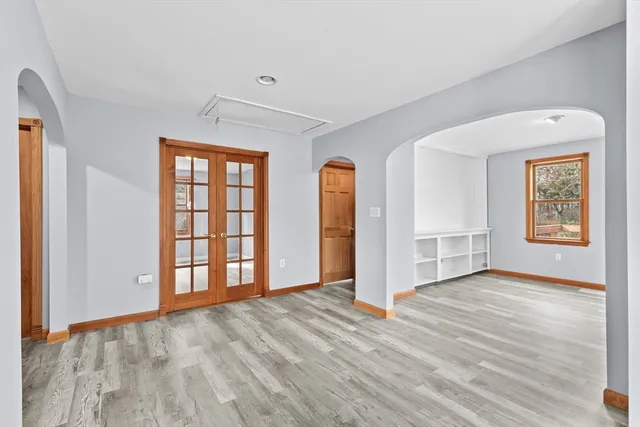 an empty room with wooden floor and windows