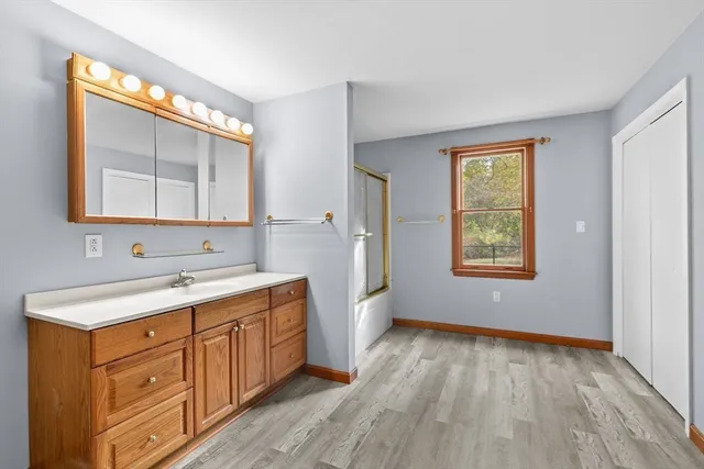 a bathroom with a sink a mirror and a window