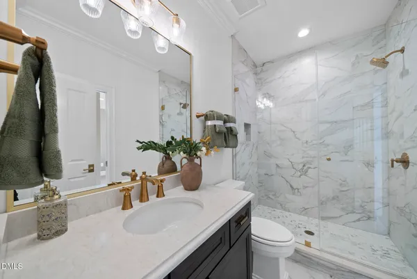 a bathroom with a granite countertop sink a toilet and shower