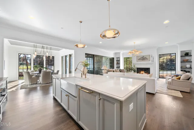 a living room with furniture a fireplace and a chandelier