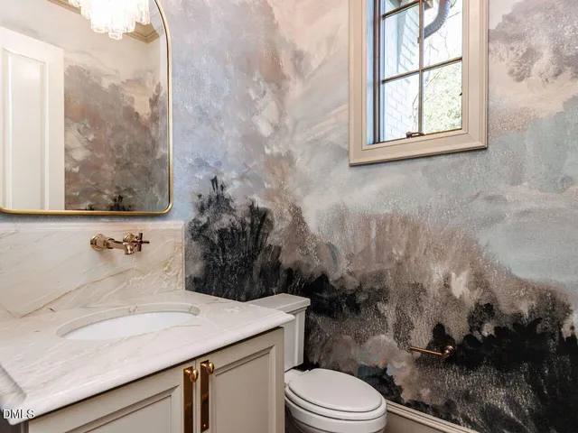 a view of an empty room with a fireplace and wooden floor