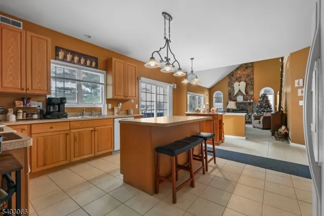 a kitchen with stainless steel appliances granite countertop wooden cabinets a dining table and chairs